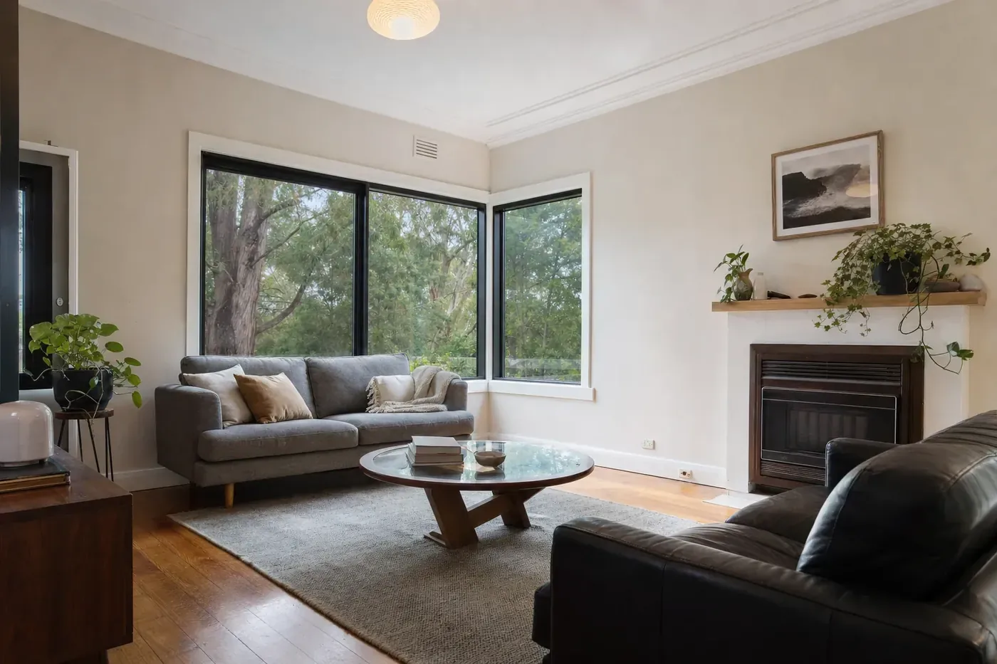 Living room of a post-war weatherboard house with black aluminium double glazed windows