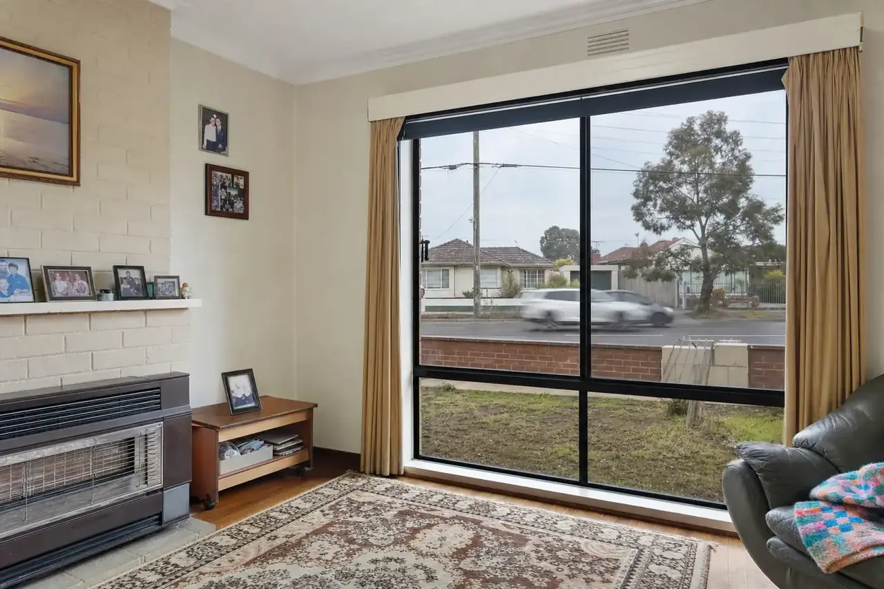 Lounge of a 1960s cream brick house with black aluminium double glazed windows