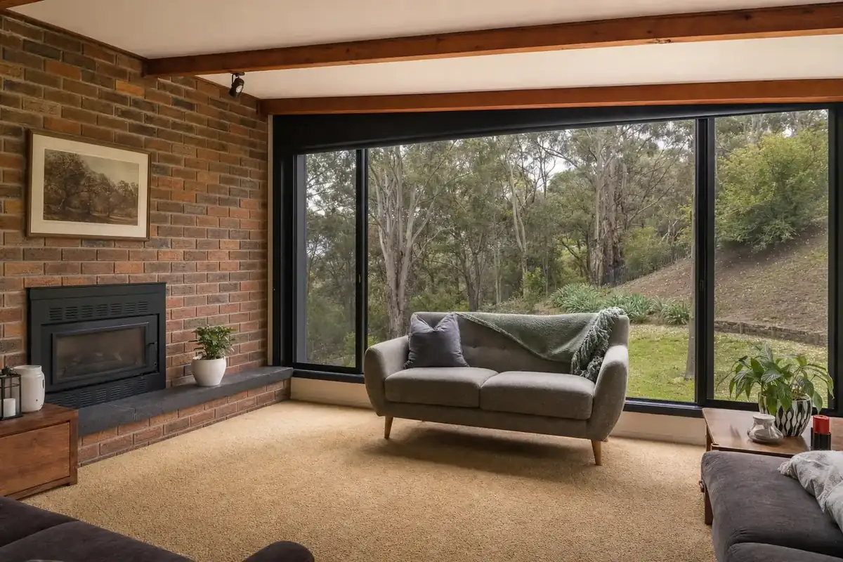 Family room of a 1970s split-level project home with black aluminium double glazed windows