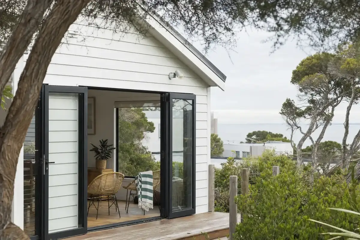 Weatherboard beach house with black aluminium double glazed windows