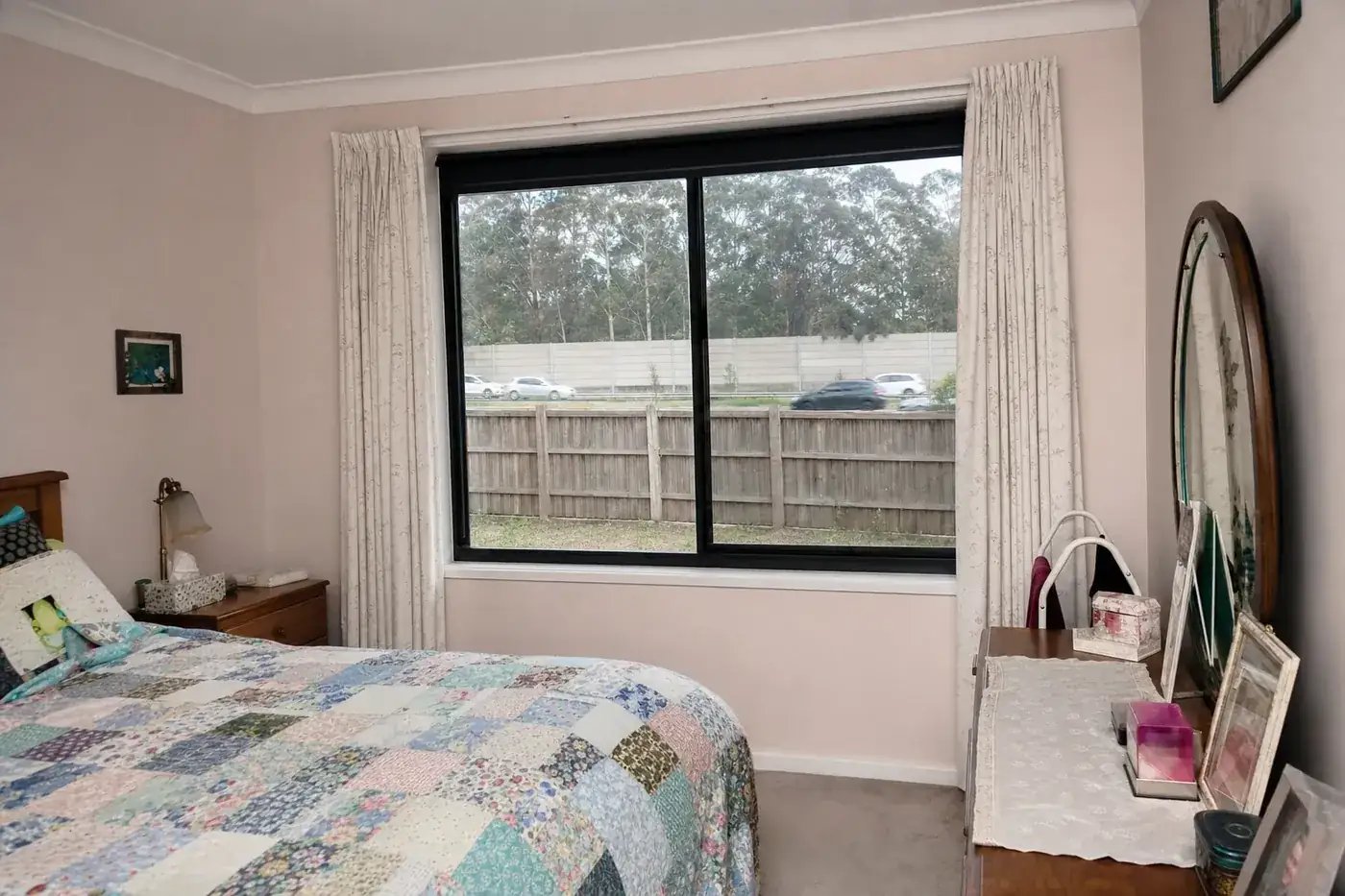 Bedroom of a 1980s brick veneer house with black aluminium double glazed windows